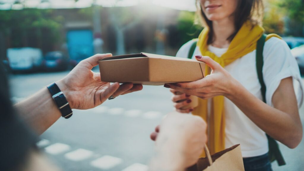 gig economy worker delivering food to a woman