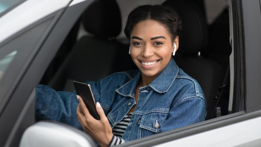 uber driver sitting in car holding phone