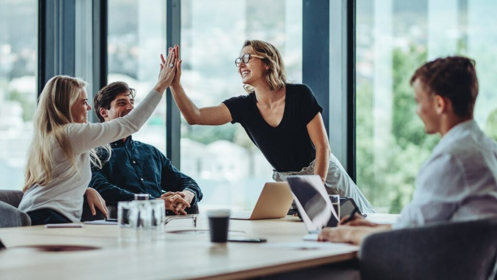 company-or-team-high-fiving-after-setting-up-expense-approval-hierarchy