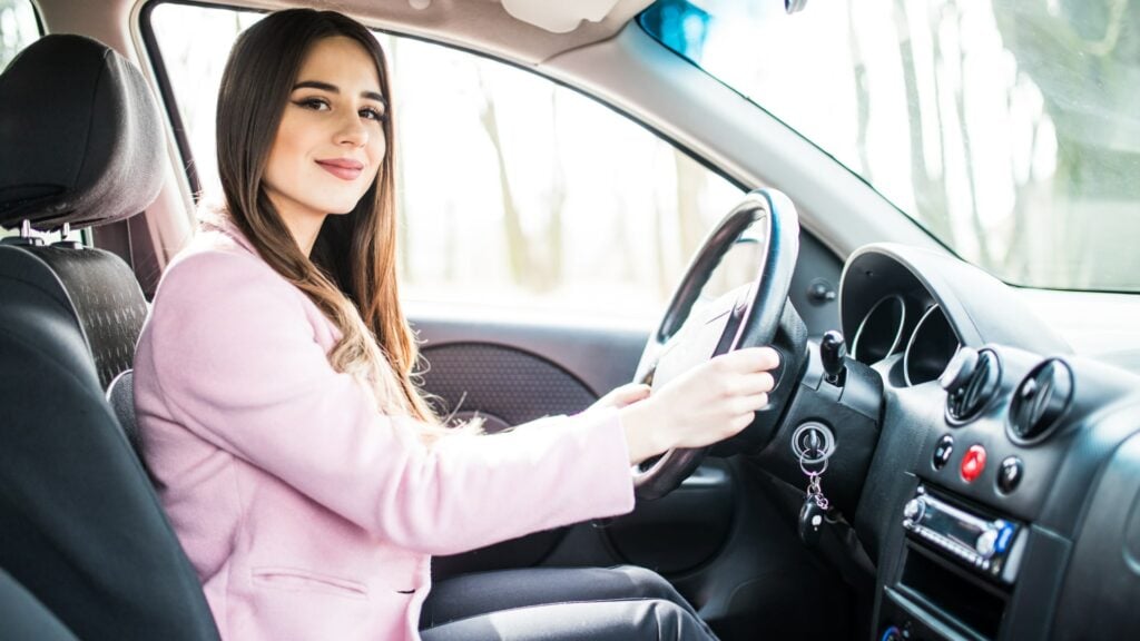 woman using her iphone in her car to track mileage