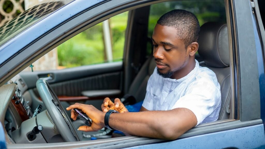 uber driver looking at his phone seeing how much he earned